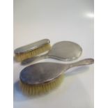 A silver backed hand mirror and matching brushes and two silver topped glass bottles (5)