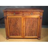 A William IV mahogany cabinet with lapit carved pillesters, panelled doors and on bun feet, 102 x