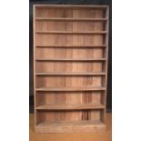 A large limed oak bookcase of eight open shelves on a plinth base, 236 x 134cm