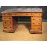A Victorian mahogany pedestal desk with remnants of a leather lined top, fitted with nine drawers