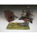 A Lyons Toffieskotch tinplate toy duck group on small wheels, a model sewing machine and a Kodak box