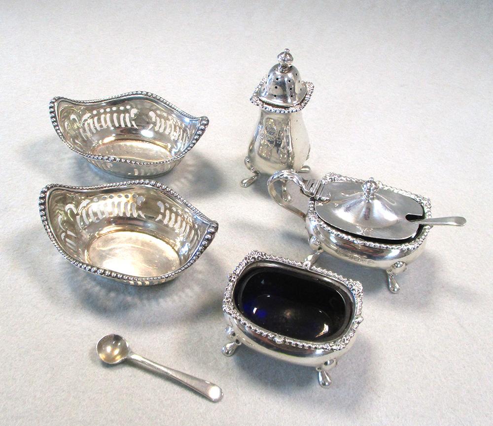 A 20th century silver three piece condiment set by Garrard & Co and a pair of pin trays, the