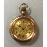 An unsigned 9ct gold lady's open faced pocket watch, the gilt floral dial with black Roman