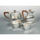 An Art Déco style silver three piece tea set with hot water jug en suite, the tea pot by Thomas