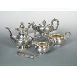 A George IV silver four piece tea and coffee set and sugar tongs on a silver plated tray, the teapot