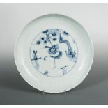 A Ming pale celadon dish, a crane to the centre in underglazed blue standing below a pine branch