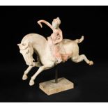 A red painted Tang dynasty pottery female polo player, astride a galloping horse, the horse