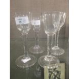 A near set of four George III cordial glasses with trumpet bowls, plain stems and folded feet (4)