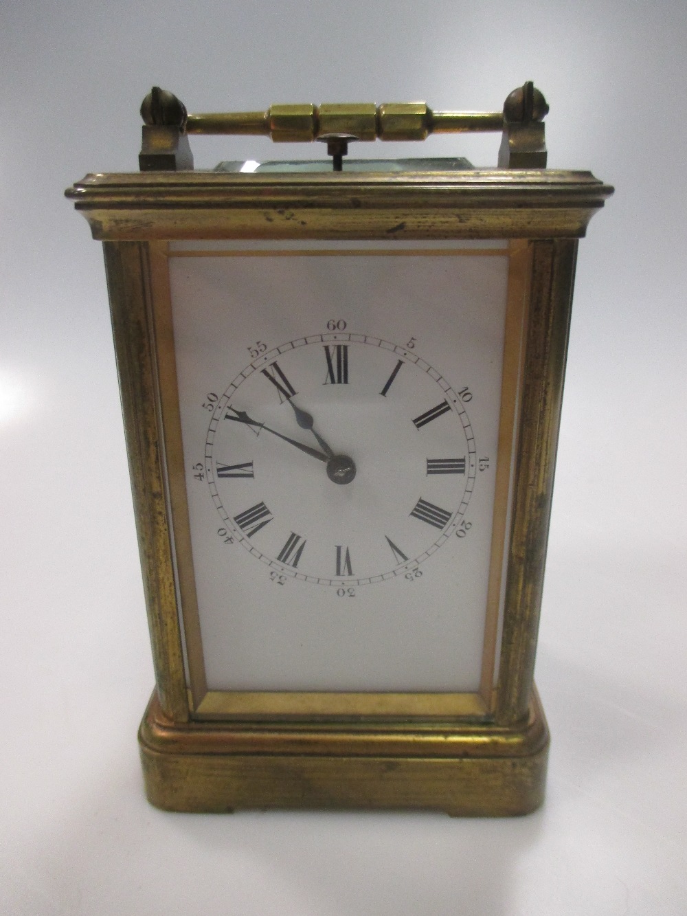 An Edwardian brass carriage clock with subsidury minute dial and striking on a coil