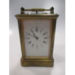 An Edwardian brass carriage clock with subsidury minute dial and striking on a coil