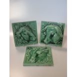 A set of three French green glazed "Butcher's Shop" square animal tiles, of pig, cow and sheep, in