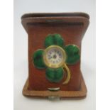 A leather cased travelling timepiece with four leaf clover enamel mount