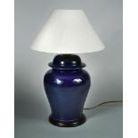 A modern blue-glazed pottery table lamp, of lidded ginger-jar form and with wooden stand and linen