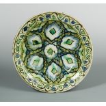 A 17th century Islamic Ottoman Iznik dish, decorated with stylised motifs within a band of scrolling