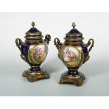 A pair of 19th century Sevres style two handled vases and covers, with gilt metal acanthus cast