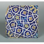 A 15th century Islamic Persian Timurid tile, decorated with stylised flower heads and motifs, within