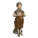 A late 19th century Austrian painted terracotta figure of a boy cobbler, possibly Goldscheider, he