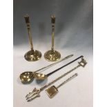 A 19th century decorative brass and iron cream skimmer, together with a pair of slender brass