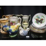 Floral jugs and teapots together with vintage tin picnic plates and china plates decorated with