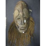 An African tribal bearded mask, 55cm high, and a standing figure, 60cm high (2)