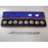 A cased set of eight silver buttons and a silver bracelet