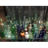 A very large quantity of glass bottles of varying sizes, salt glazed jars and various oil lamps