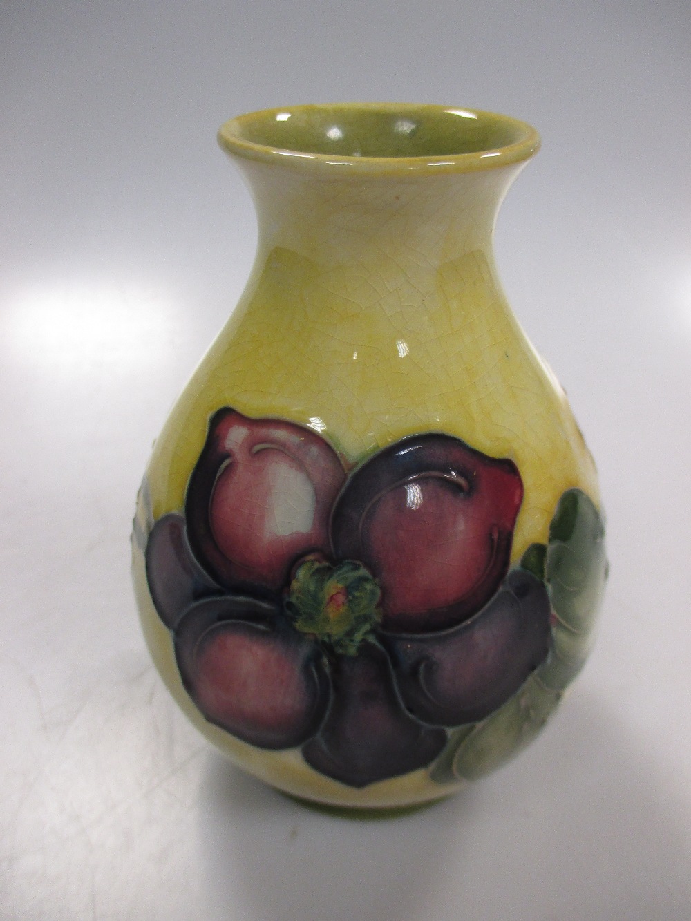 A Moorcroft vase, the yellow ground with clematis flowers, 11cm high