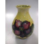 A Moorcroft vase, the yellow ground with clematis flowers, 11cm high