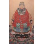 A Chinese ancestral portrait, the sitter seated wearing an elaborate robe in a chair draped with a