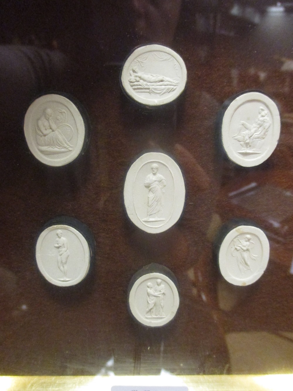 A cased set of seven intaglios, depicting classical scenes