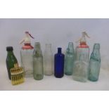 Two glass soda syphons and a selection of glass bottles.