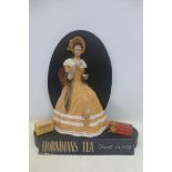 A rare Hornimans Tea pictorial 3D shop window display, depicting a well dressed lady drinking a