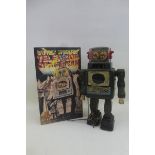 A Japanese battery operated tinplate television spaceman robot with reproduction box.