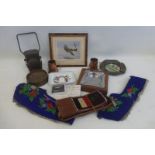 An assortment of military and other items including a WWII bicycle lamp and an ashtray.