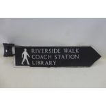 A directional street sign for Riverside Walk, Coach Station and Library, 33 1/2 x 8 1/4".