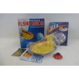 A boxed flying saucer and a wind-up UFO made in Hong Kong.