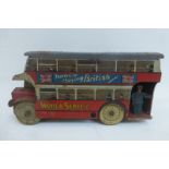 A tinplate model bus, with advertising all around.