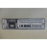 A small, narrow black and white enamel strip advertising J.W. Bridge, Church Street, Accrington
