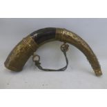 A large decorative horn and brass shot flask.