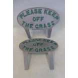 A pair of modern 'Keep off the grass' signs.