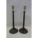 A pair of 19th Century mahogany fluted table candlesticks with cast brass sconces.