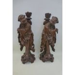 A pair of well carved hardwood standing figures, forming lamps.