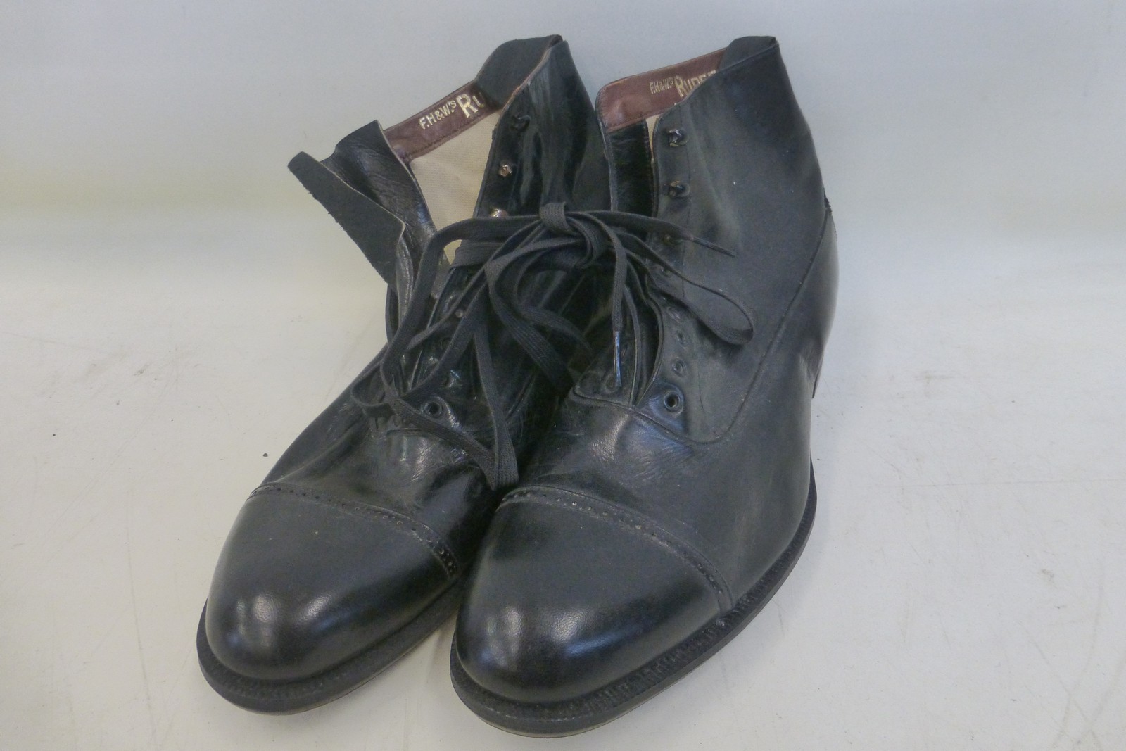 A pair of black leather lace-up shoes F.H & U's RUPERT, with tan leather soles.