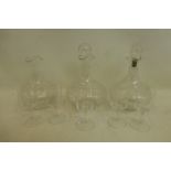 Three etched glass decanters and five similarly etched drinking glasses.