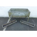 A large 'D' shaped galvanised feeding trough and two small galvanised feeding troughs.