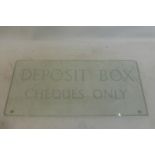 A glass sign with white lettering 'Deposit box cheques only', 18 1/4 x 8".