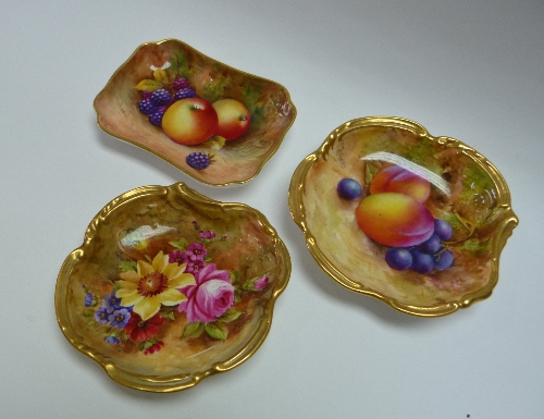 A pair of Royal Worcester porcelain pin Dishes, of scrolled circular form with gilt borders, painted