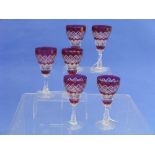 A set of six continental ruby-flashed Wine Glasses, each with a bell-shaped bowl cut with hobnails