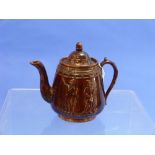 A Victorian treacle glazed Teapot, pear-shaped with acorn finial and scroll handle, moulded in