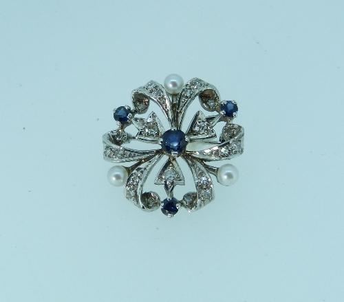 A 9ct white gold circular open work Brooch, set with small diamonds, sapphires and cultured